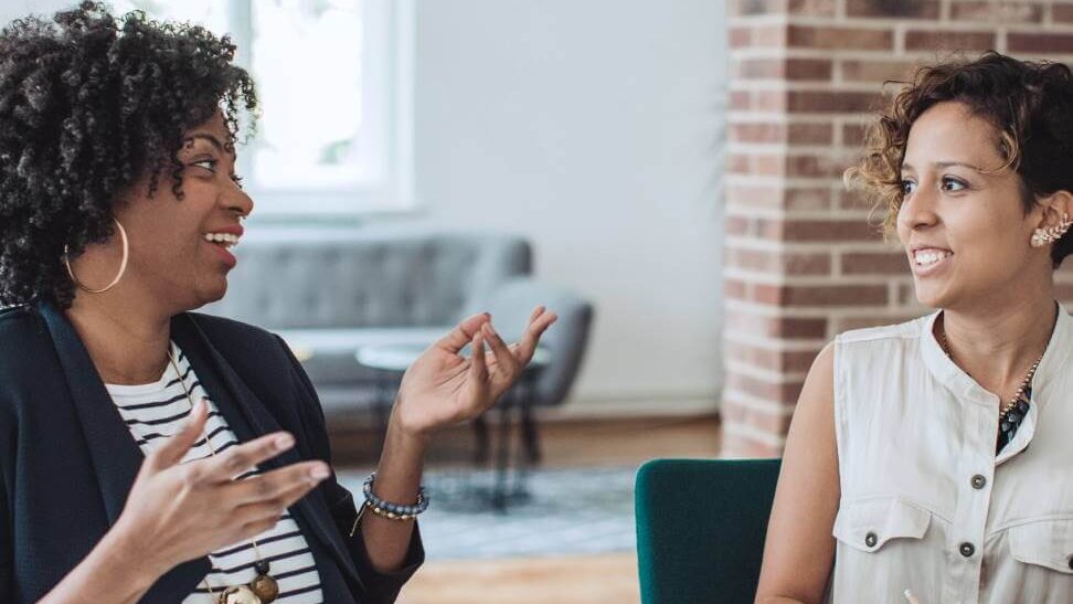 Coworkers seated at desk having a discussion