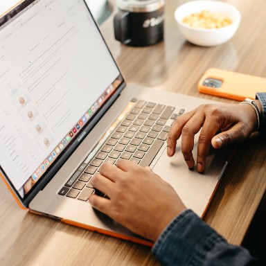 A pair of hands resting on a laptop keyboard.