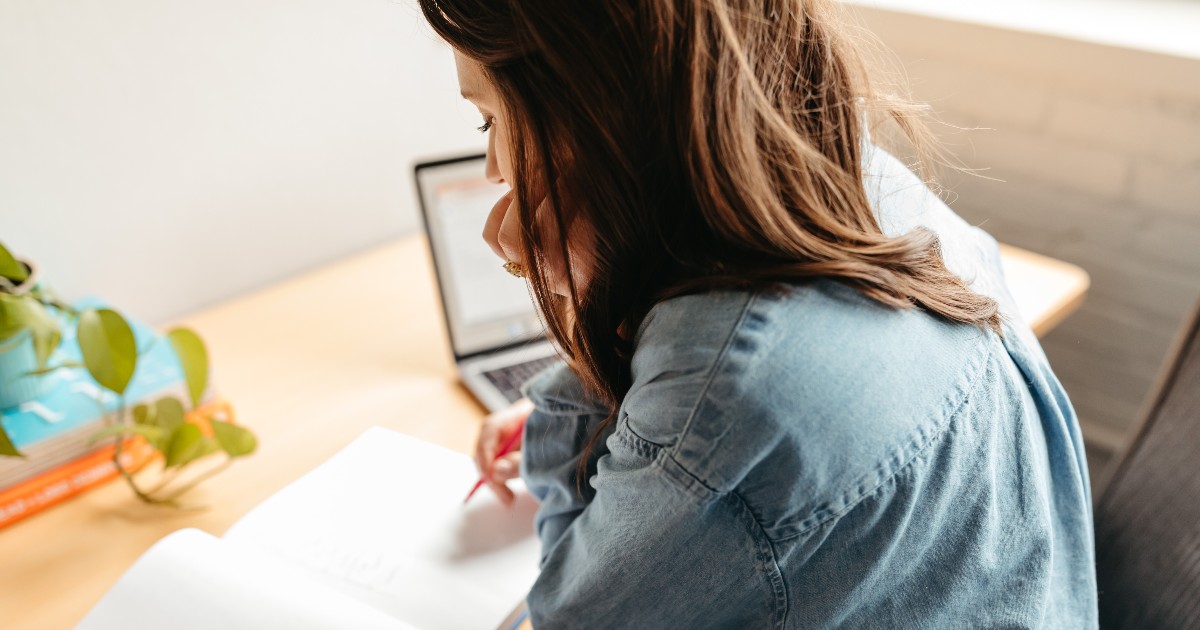 A woman writing at her desk.