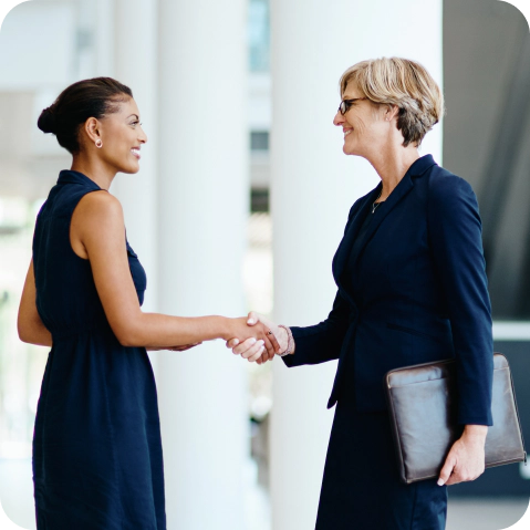 Two business women shaking hands.