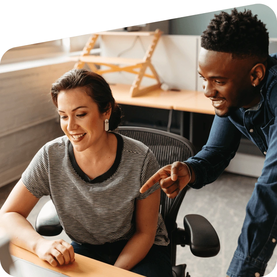 Two people looking at a workstation.