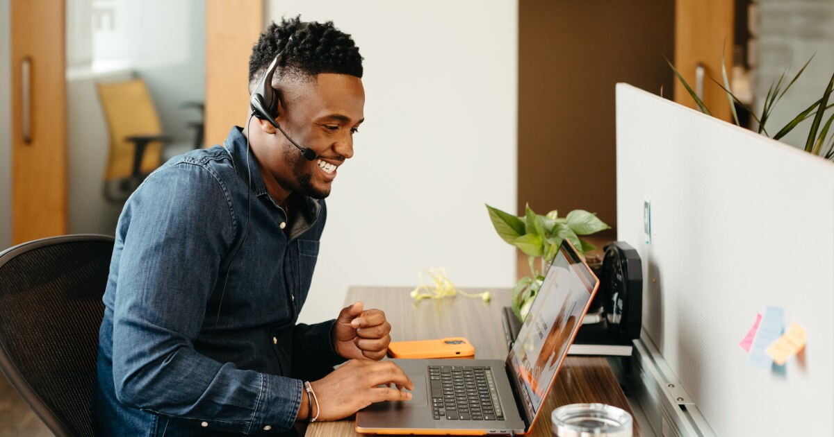 Man with headphones looking at laptop.