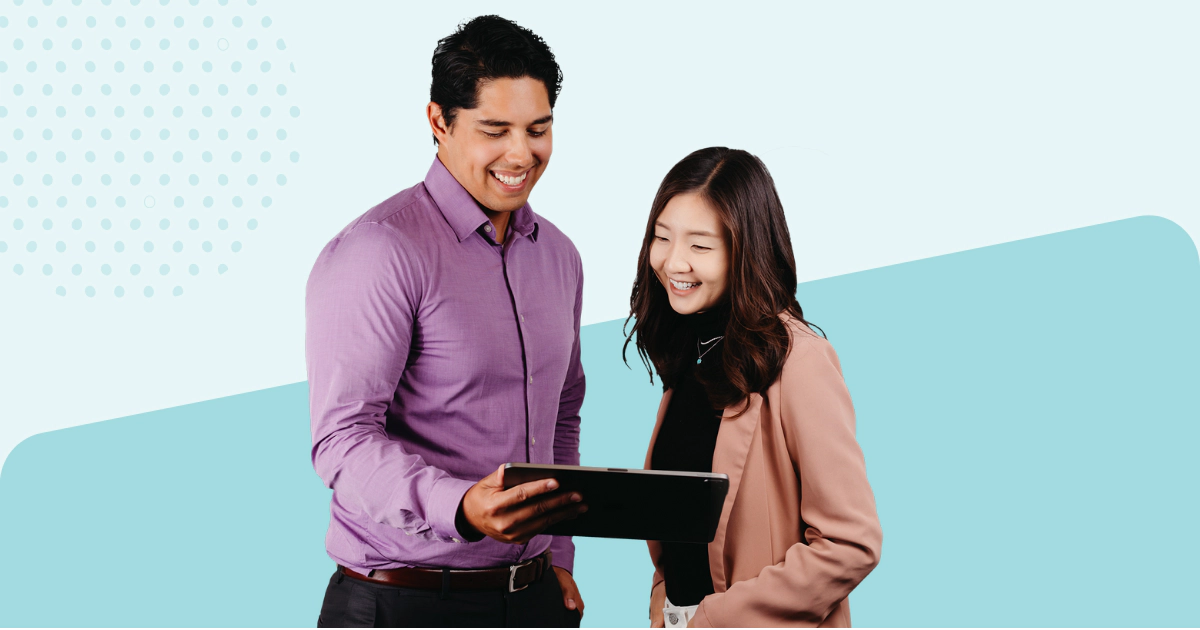 Two smiling business people looking at laptop.