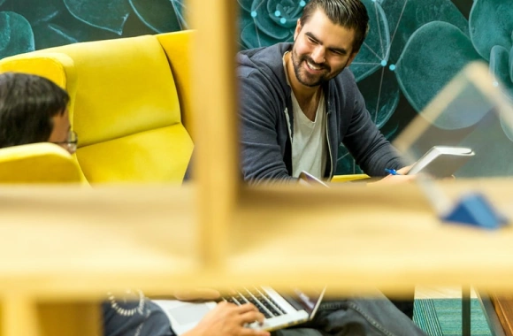 Two men seated in a lobby.