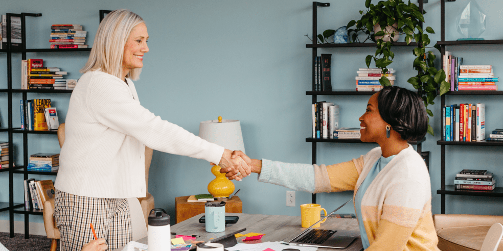 Two women shaking hands.